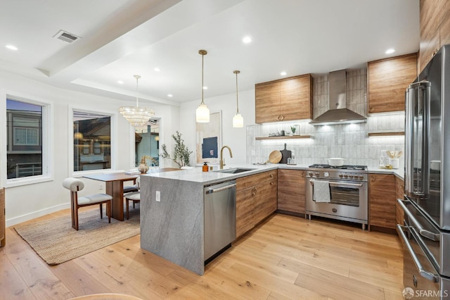 57 Niagara Ave, San Francisco, CA 94112 - kitchen featuring premium appliances, brown cabinetry, wall chimney exhaust hood, light countertops, and recessed lighting
