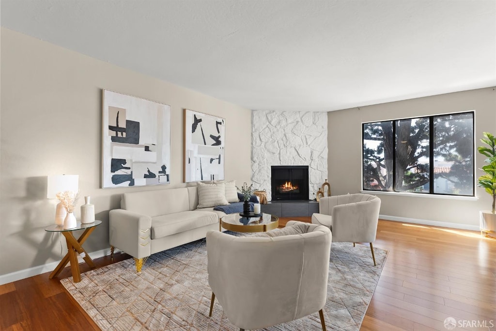 1550 Bancroft Ave Unit 321, San Leandro, CA 94577 - living area with a stone fireplace, wood finished floors, and baseboards