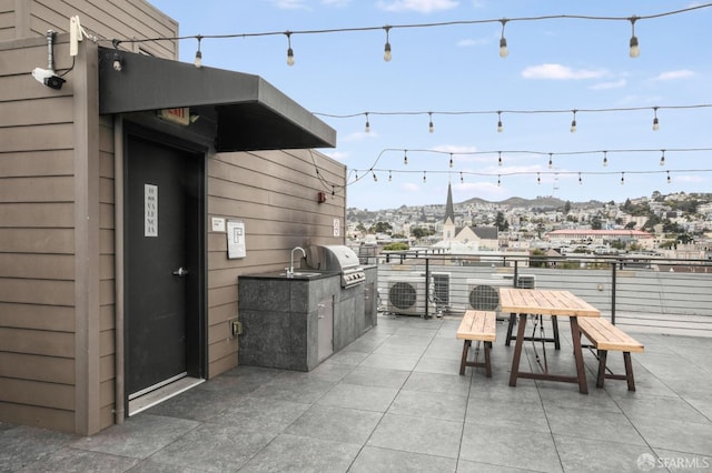 view of patio with exterior kitchen, a mountain view, and area for grilling