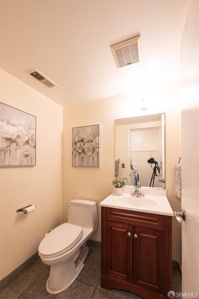 half bathroom featuring visible vents, baseboards, toilet, and granite finish floor