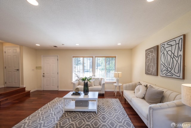 living room featuring visible vents, a textured ceiling, baseboards, and dark wood-style flooring