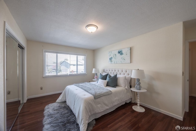 bedroom with wood finished floors, baseboards, a closet, and a textured ceiling