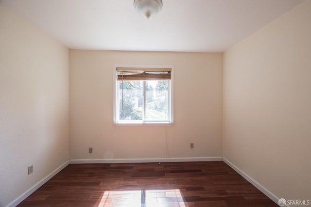 empty room with baseboards and wood finished floors