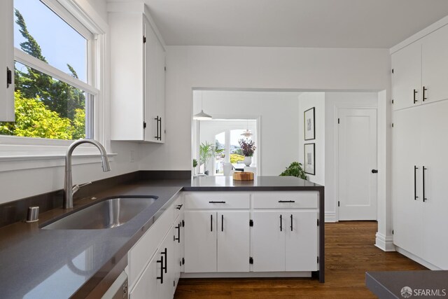 130 Cerritos Ave, San Francisco, CA 94127 - kitchen with a sink, dark countertops, white cabinetry, dark wood-style floors, and a peninsula