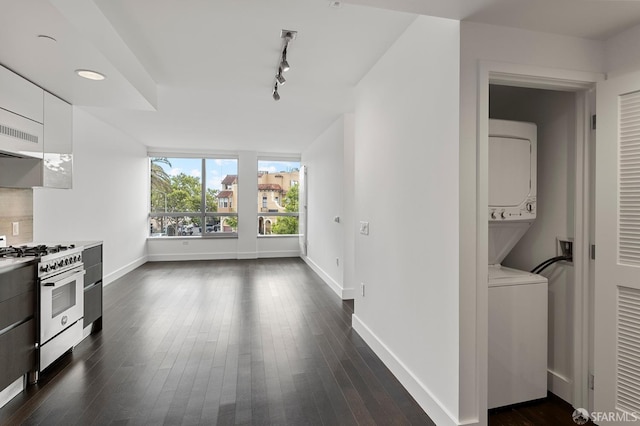 8 Buchanan St Unit 202, San Francisco, CA 94102 - kitchen with stainless steel gas range oven, stacked washer and clothes dryer, white cabinets, baseboards, and dark wood finished floors