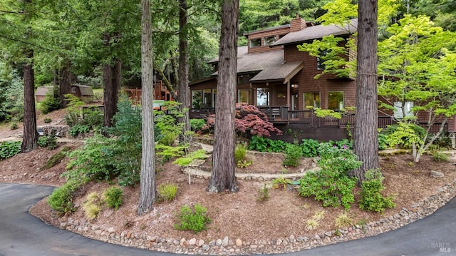 view of front of home featuring a chimney and a shingled roof