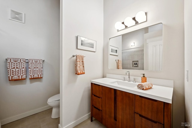 bathroom with toilet, visible vents, vanity, and baseboards