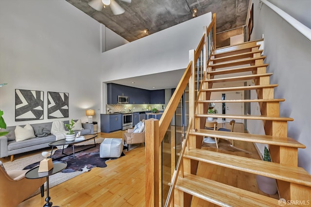 stairway featuring hardwood / wood-style floors and a towering ceiling