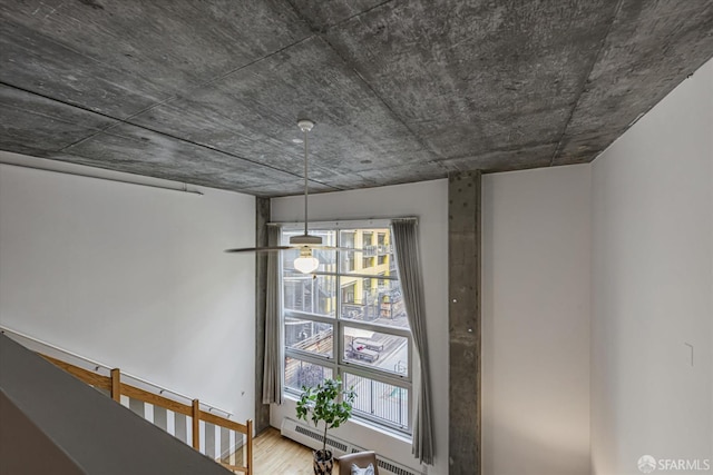 interior details with wood-type flooring and a baseboard heating unit