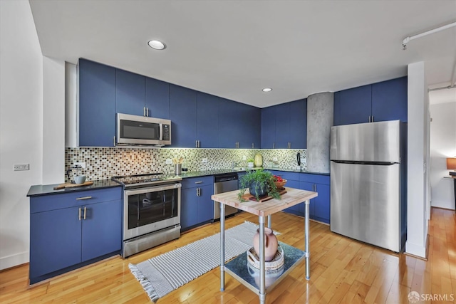 kitchen with blue cabinetry, tasteful backsplash, light hardwood / wood-style flooring, and stainless steel appliances