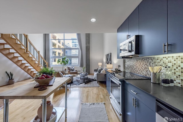 kitchen with backsplash, light hardwood / wood-style flooring, blue cabinets, and electric stove