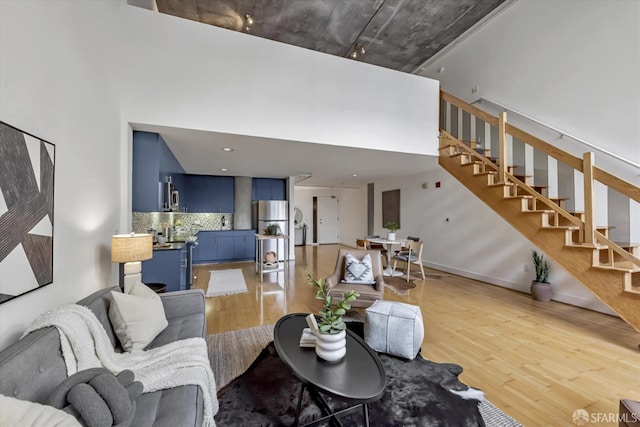 living room with a high ceiling and light wood-type flooring