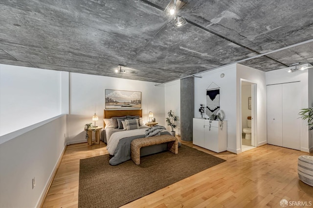 bedroom with hardwood / wood-style floors and connected bathroom