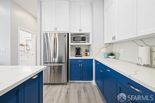 3000 26th St, San Francisco, CA 94110 - kitchen with appliances with stainless steel finishes, blue cabinets, decorative backsplash, and white cabinetry
