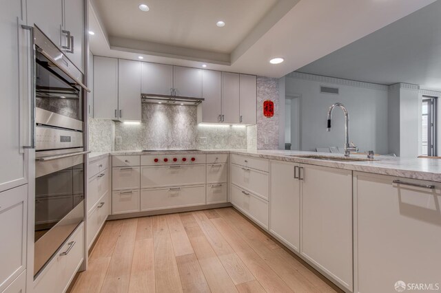 875 California St Unit 403, San Francisco, CA 94108 - kitchen featuring a sink, appliances with stainless steel finishes, backsplash, light wood finished floors, and recessed lighting
