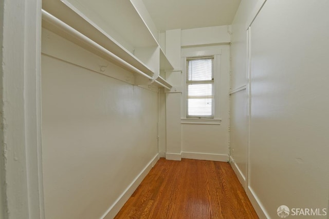 walk in closet with wood finished floors