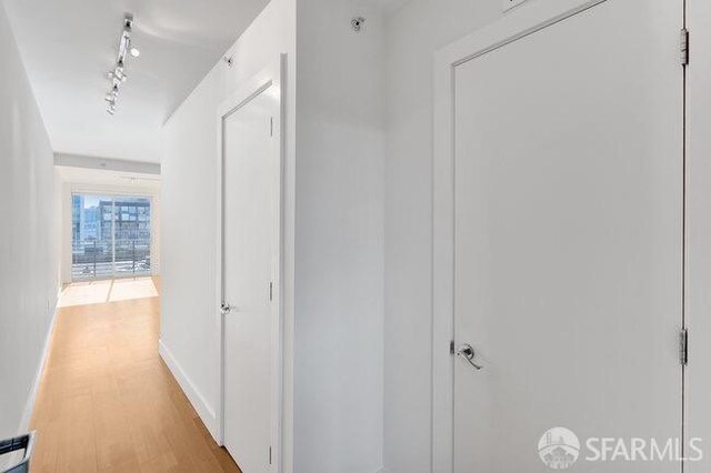 hall featuring light hardwood / wood-style flooring and rail lighting