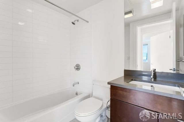 full bathroom featuring tiled shower / bath, vanity, and toilet