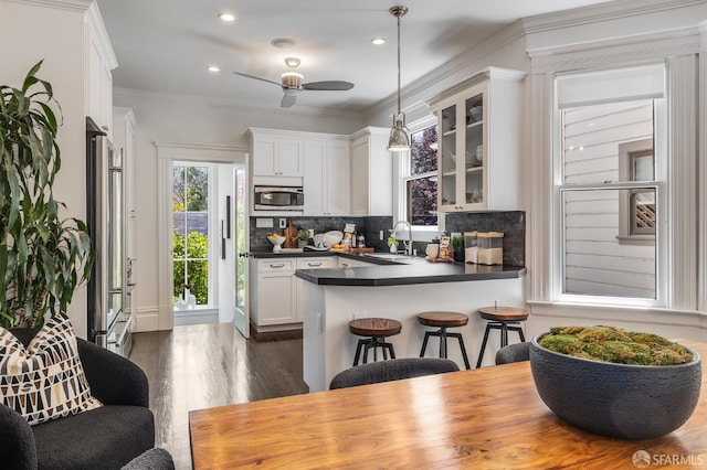 438 Broderick St, San Francisco, CA 94117 - kitchen with stainless steel appliances, a sink, dark countertops, a ceiling fan, and glass insert cabinets