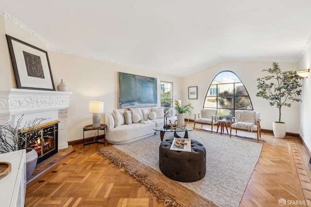 living room featuring a premium fireplace, light parquet flooring, and vaulted ceiling