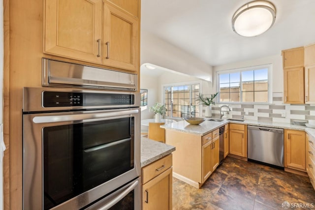 kitchen with appliances with stainless steel finishes, light stone countertops, sink, and decorative backsplash