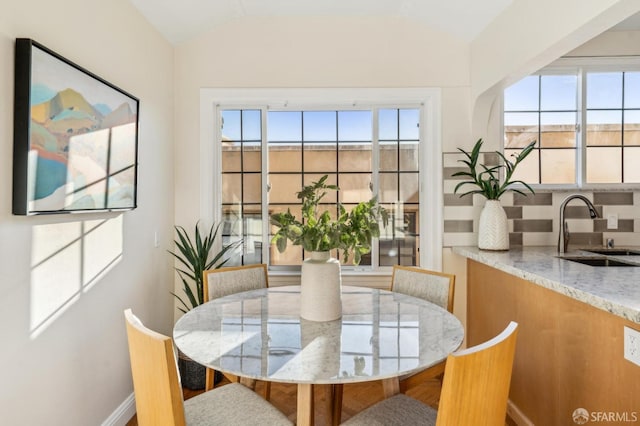 dining area with sink and vaulted ceiling