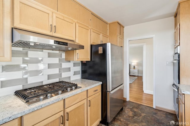 kitchen featuring light stone counters, stainless steel appliances, and light brown cabinetry