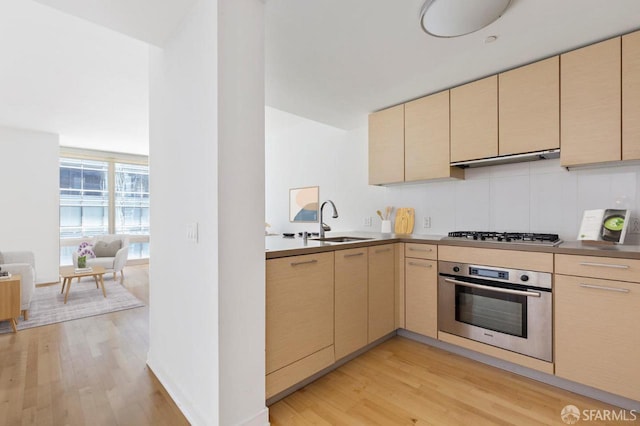 301 Mission St Unit 8E, San Francisco, CA 94105 - kitchen featuring appliances with stainless steel finishes, cream cabinetry, and light wood finished floors