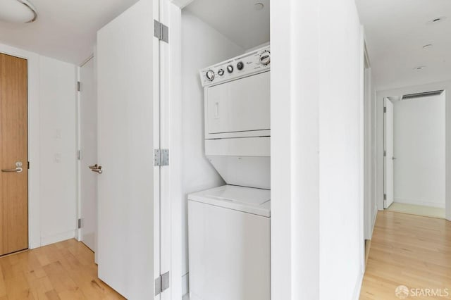 301 Mission St Unit 8E, San Francisco, CA 94105 - laundry area featuring stacked washing machine and dryer and light wood-style floors
