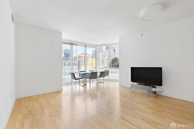 301 Mission St Unit 8E, San Francisco, CA 94105 - living room featuring wood finished floors, a wall of windows, and baseboards