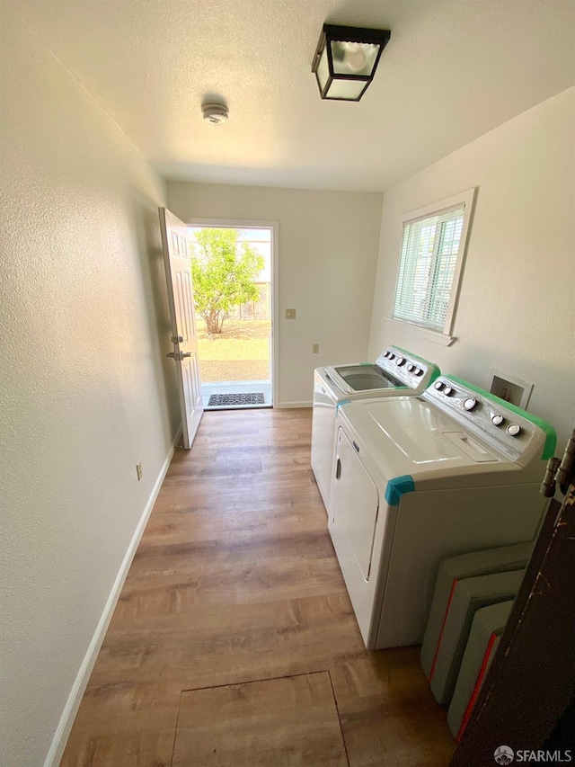 washroom with washer and dryer, baseboards, light wood-style floors, and laundry area