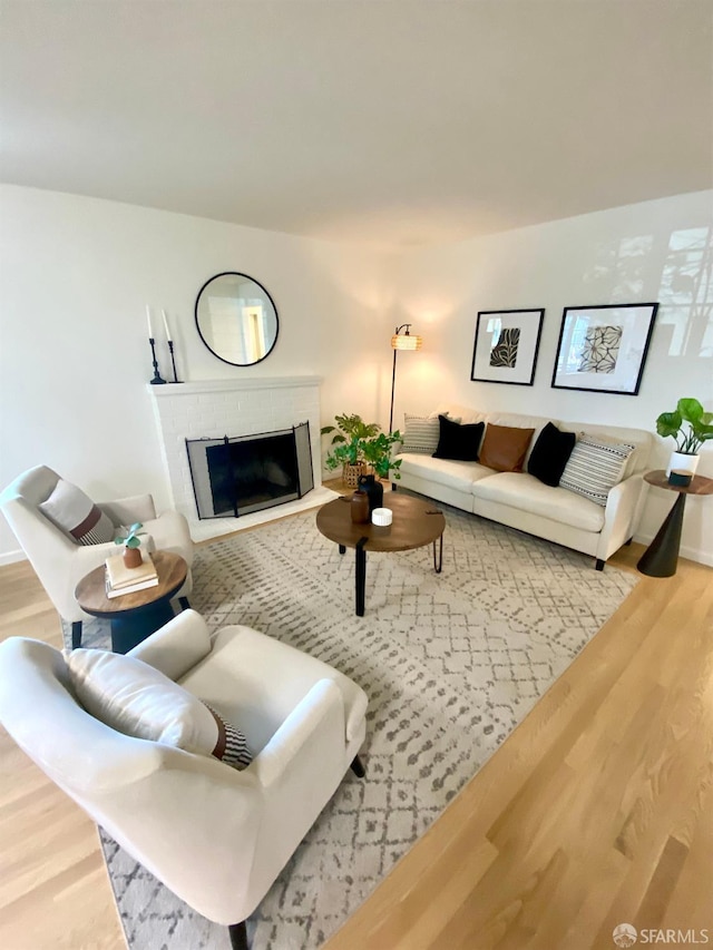 living room with a fireplace and wood finished floors