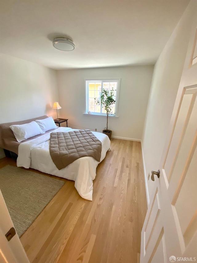 bedroom with light wood-style flooring and baseboards