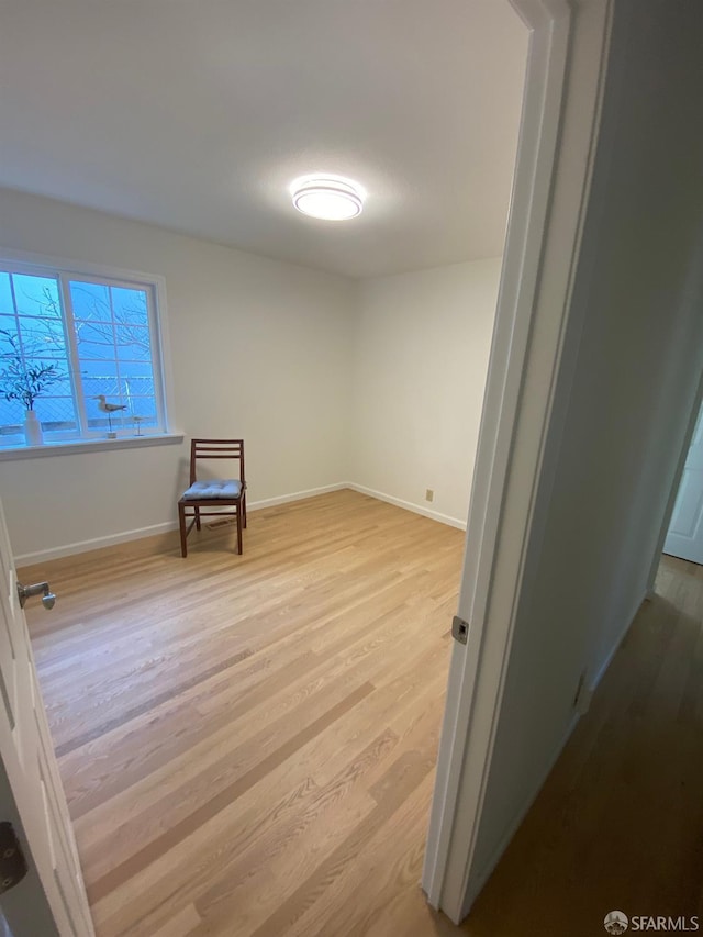 spare room with light wood-style floors and baseboards