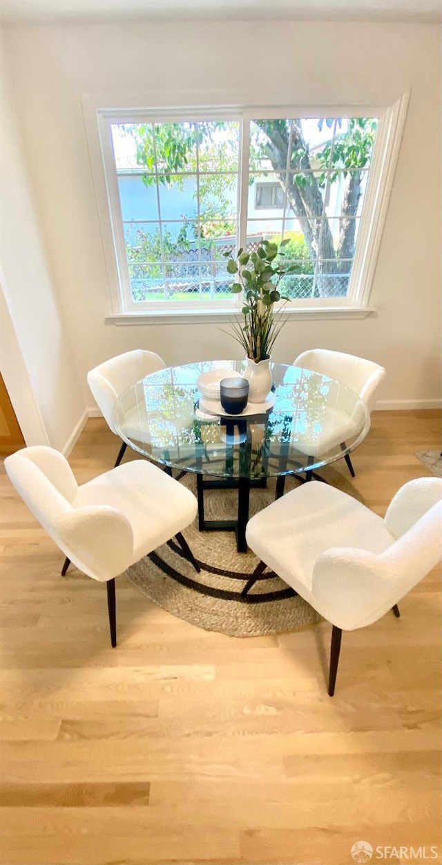 dining space featuring wood finished floors and baseboards