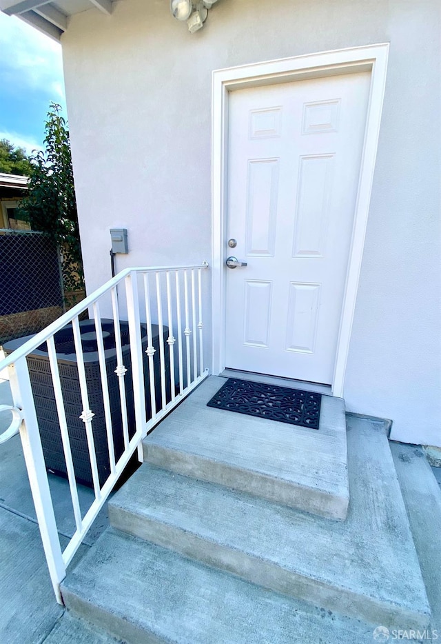 doorway to property featuring stucco siding