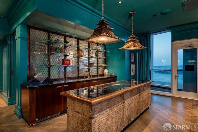 bar featuring pendant lighting and hardwood / wood-style flooring