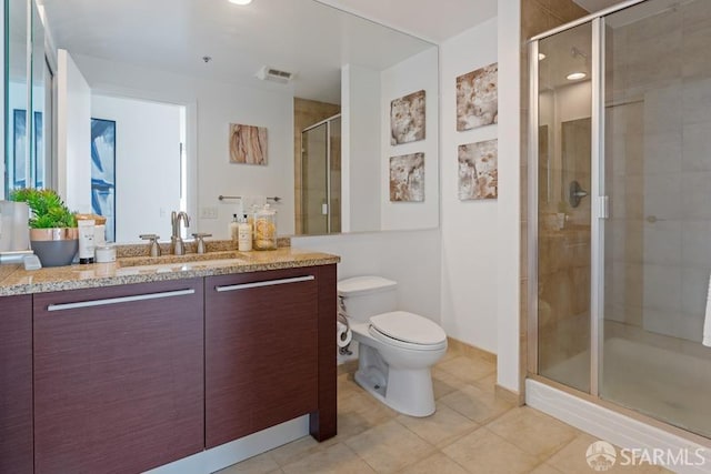 bathroom featuring tile patterned flooring, toilet, an enclosed shower, and vanity