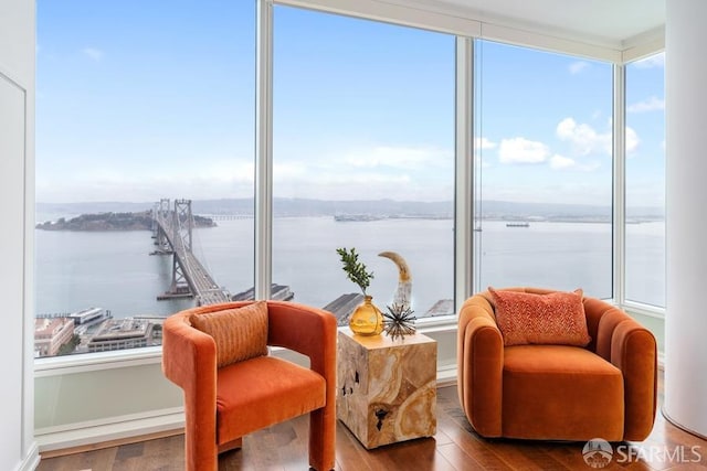 living area with hardwood / wood-style flooring and a water view