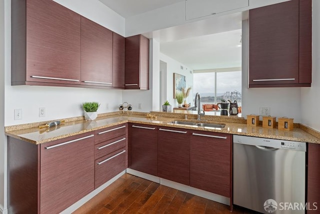 kitchen with dark hardwood / wood-style flooring, light stone countertops, sink, and stainless steel dishwasher