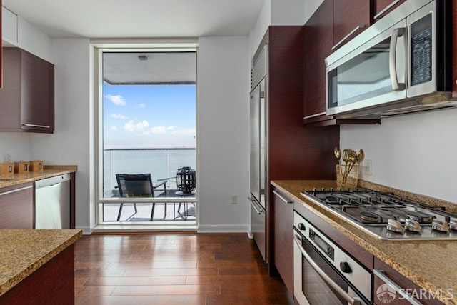 kitchen with dark brown cabinetry, dark hardwood / wood-style flooring, and stainless steel appliances