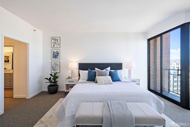 bedroom featuring dark carpet and ensuite bathroom