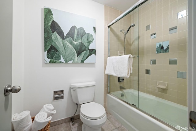 bathroom featuring tile patterned flooring, shower / bath combination with glass door, and toilet