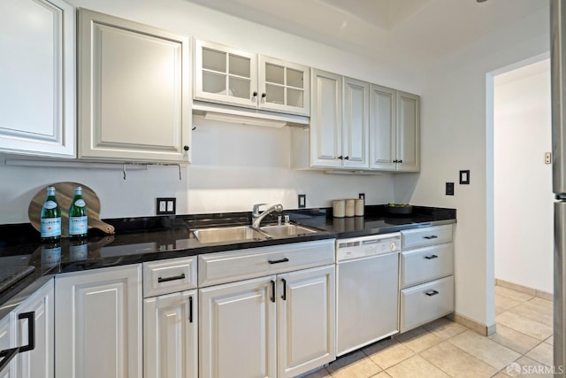 kitchen with white cabinets, white dishwasher, light tile patterned floors, and sink