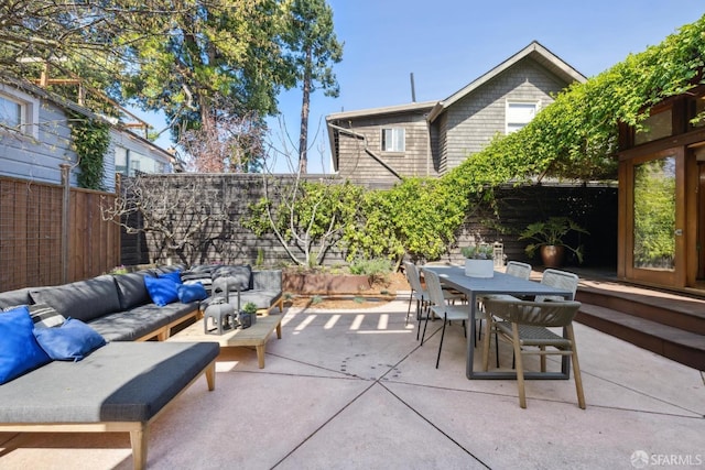 view of patio with outdoor dining space, an outdoor living space, and a fenced backyard