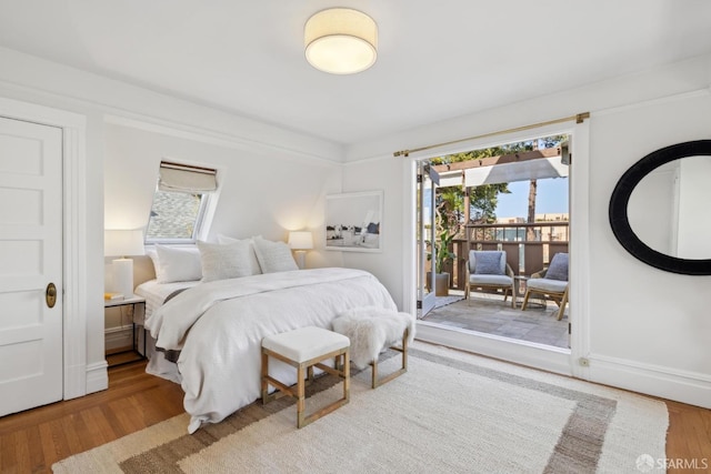 bedroom featuring access to outside and wood finished floors