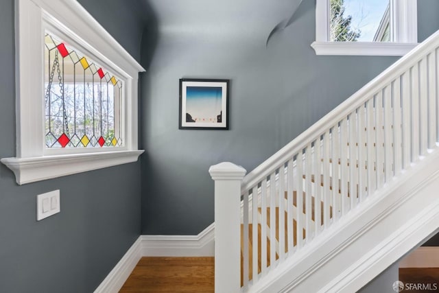 stairway featuring baseboards and wood finished floors