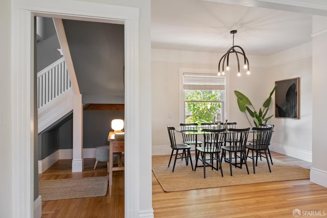 dining space with an inviting chandelier, wood finished floors, and baseboards