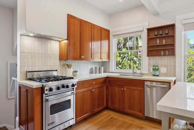 kitchen featuring a healthy amount of sunlight, stainless steel appliances, light countertops, and a sink