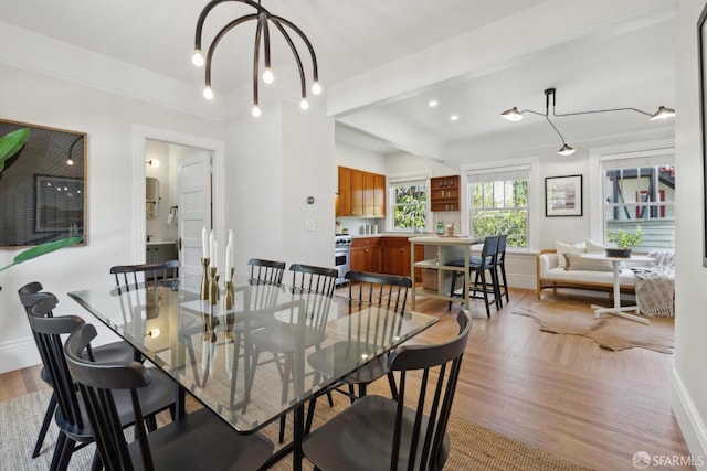 dining area featuring beamed ceiling, baseboards, and light wood-type flooring